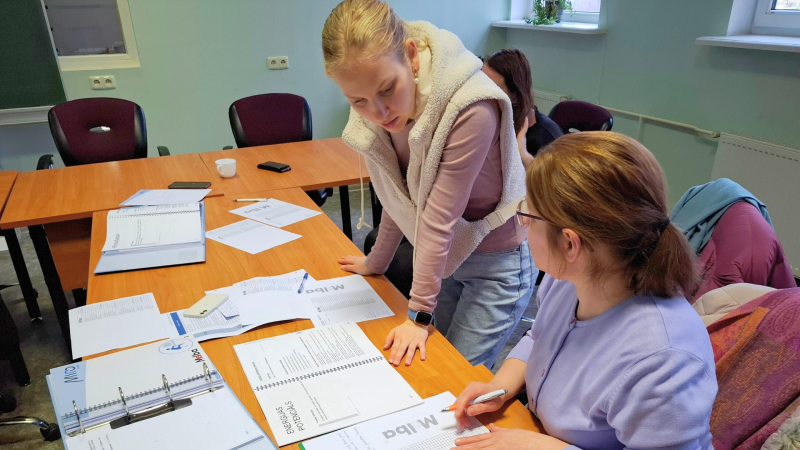 Ergoterapeites Anita Maizīte un Alīvija Priedīte iepazīstas ar mācību materiāliem