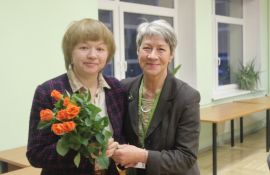 Izstādes autore Marika Dimperāne tur rokās oranžu rožu pušķi. Viņai blakus stāv Jūrmalas profesionālās vidusskolas vadītāja Valda Puiše
