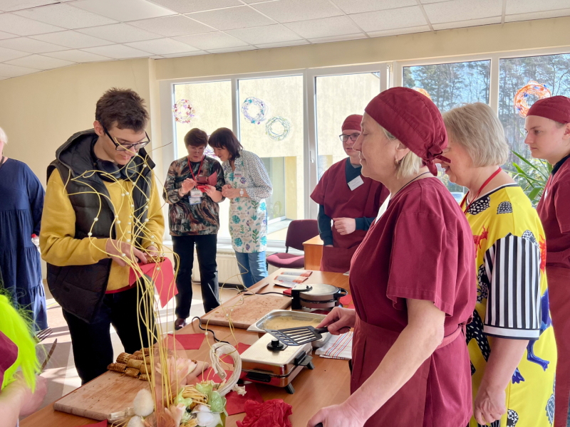 Topošie pavāri ar pasniedzēju demonstrē vafeļu pagatavošanu.