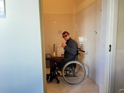 cilvēks ratiņkrēslā izmēģina pielāgotās telpas