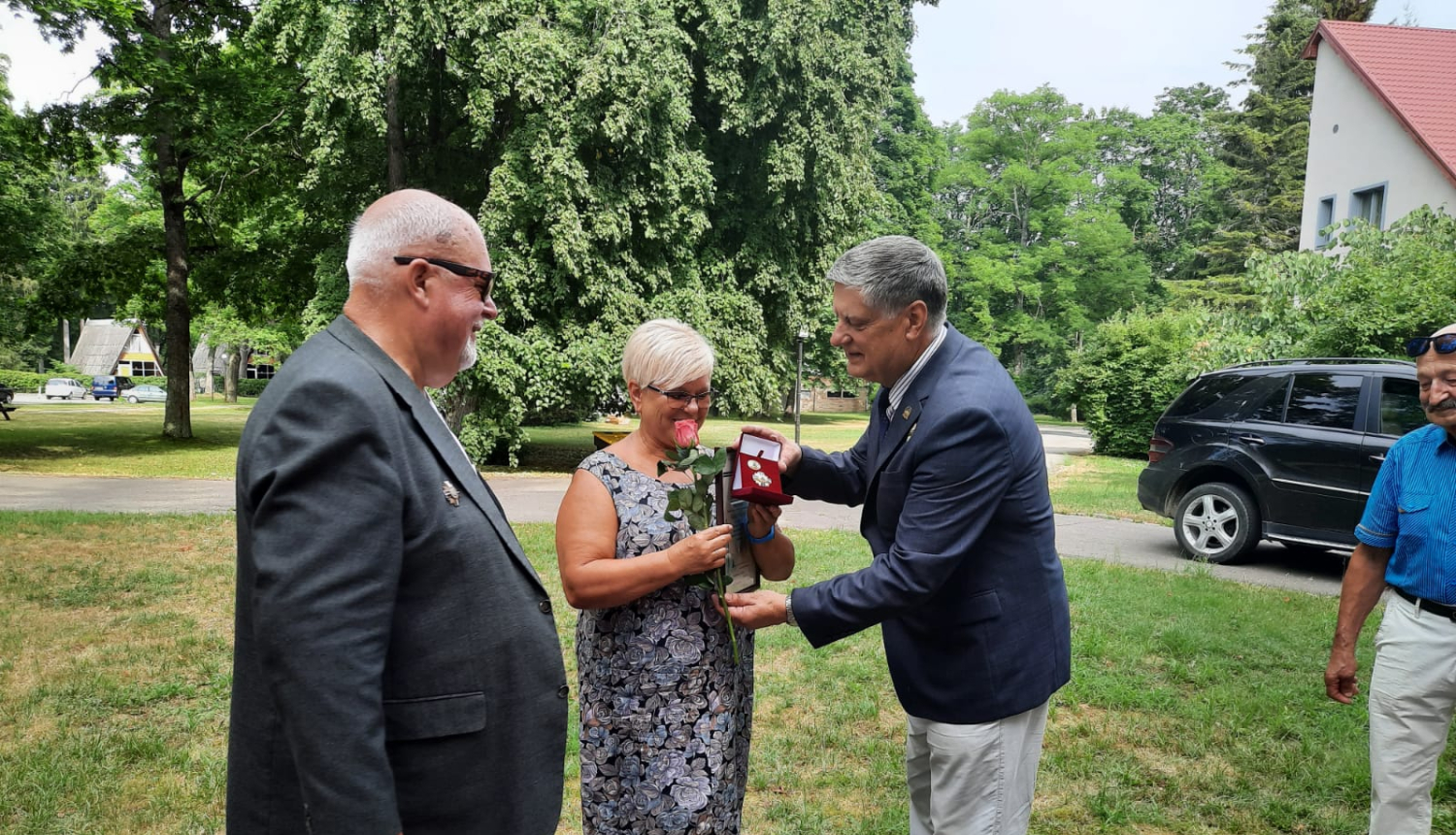 Latvijas savienības "Černobiļa" pārstāvis sniedz SIVA darbiniecei rozā rozi un sarkanā kārbiņā ievietotu apbalvojumu "Goda zīme"