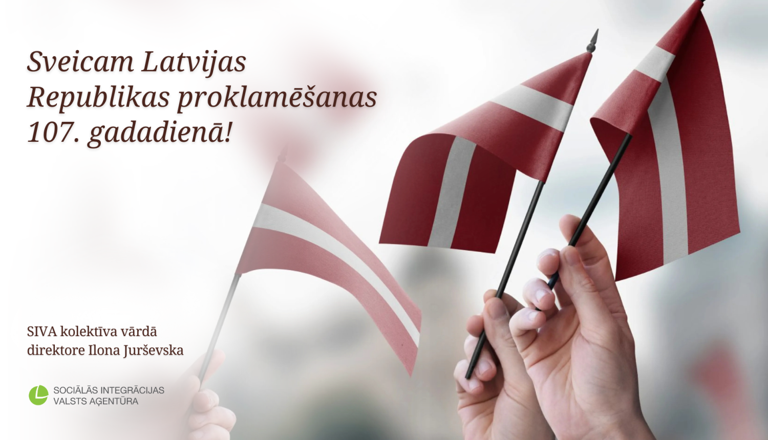 Cilvēki tur rokās Latvijas karogus un blakus sveiciens Latvijas Republikas proklamēšanas 107. gadadienā